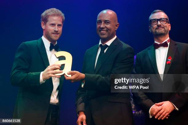 Prince Harry, left, receives a posthumous Attitude Legacy Award on behalf of his mother Diana, Princess of Wales, from Ian Walker, right, and Julian...