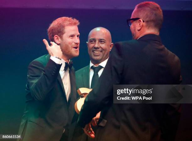 Prince Harry receives a posthumous Attitude Legacy Award on behalf of his mother Diana, Princess of Wales, from Ian Walker, right, and Julian La...