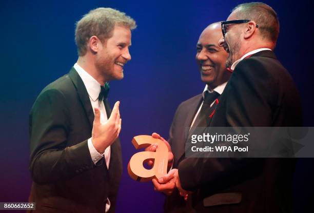 Prince Harry, left, receives a posthumous Attitude Legacy Award on behalf of his mother Diana, Princess of Wales, from Ian Walker, right, and Julian...