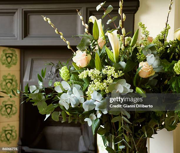 arrangement of calla lilies and roses near fireplace mantel - rosa mantel stock pictures, royalty-free photos & images