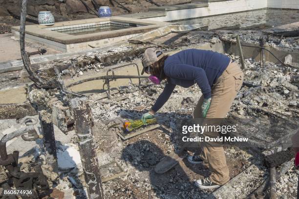 Mimi Rippey lays flowers on the spot where her mother died, in the ruins of the house of 100-year-old Charles and 98-year-old Sara Rippey who were...