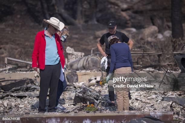 Rippey family sons Mike and Chuck, and daughters Mimi and Liz say a prayer over the spot where their father died, in the ruins of the house of...