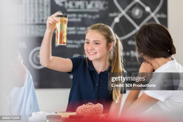 middle school girl examines crawfish inside glass jar - brain in a jar stock pictures, royalty-free photos & images