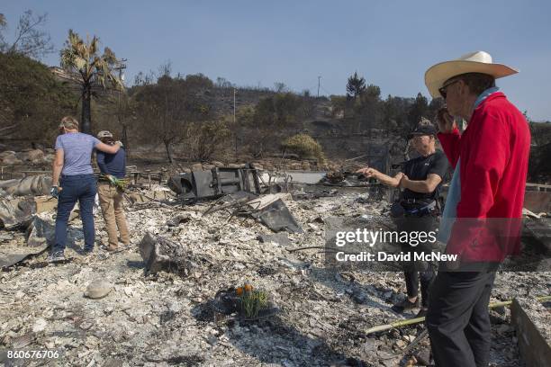 Flowers mark the spot where their father died as Rippey family daughters Liz and Mimi, and sons Chuck and Mike stand in the ruins of a house on...