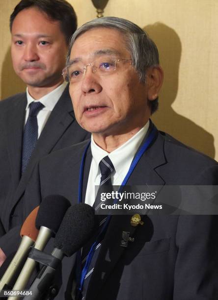 Bank of Japan Governor Haruhiko Kuroda speaks to reporters in Washington on Oct. 12 before a two-day Group of 20 financial meeting starts later in...