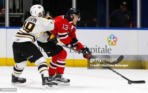 Austin Eastman of the Quebec Remparts controls the puck against Felix Boivin of the Victoriaville Tigres during the first period of their QMJHL...