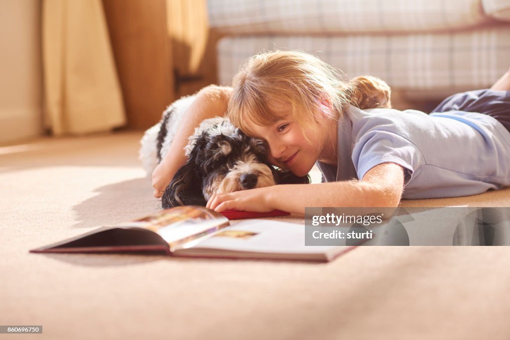 Cudding her dog reading a book