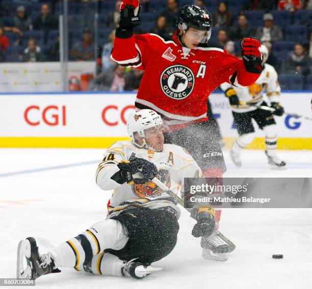 Maxime Comtois of the Victoriaville Tigres falls on the ice as he tries to control the puck against the Quebec Remparts during the second period of...