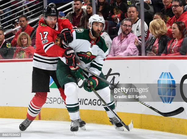 Lance Bouma of the Chicago Blackhawks and Kyle Quincey of the Minnesota Wild get physical in the first period at the United Center on October 12,...