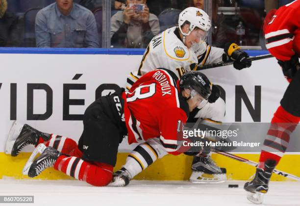 Mikael Robidoux of the Quebec Remparts and James Phelan of the Victoriaville Tigres battle for the puck during the second period of their QMJHL...