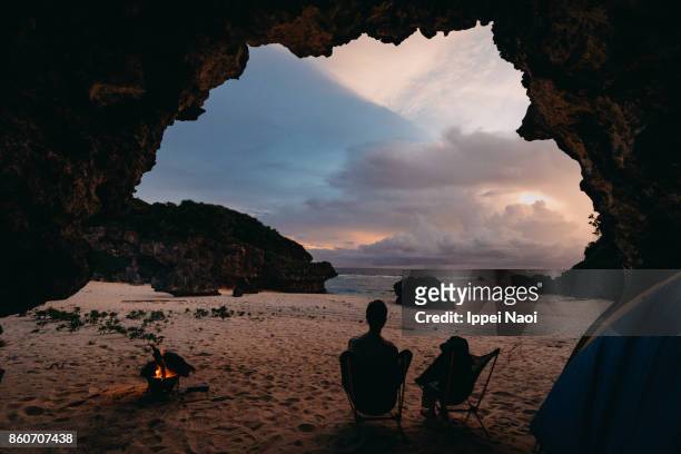 wild camping in cave on beach with sunset, japan - feu plage photos et images de collection
