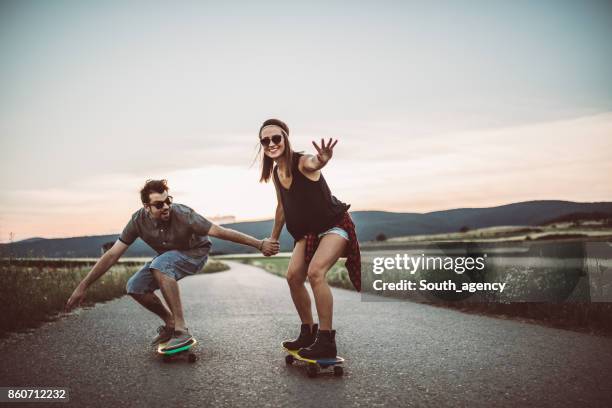 hipster couple skateboarding - couple skating stock pictures, royalty-free photos & images