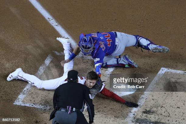 Willson Contreras of the Chicago Cubs tags out Trea Turner of the Washington Nationals at the plate during the first inning in game five of the...