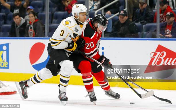 Andrew Coxhead of the Quebec Remparts and Andrew Smith of the Victoriaville Tigres battle for the puck during the third period of their QMJHL hockey...
