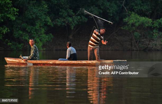 Fisherman Edmilson Ferreira throws a harpoon into the water as he fishes for arapaima, also known as pirarucu in the Western Amazon region near Volta...