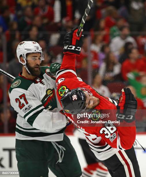 Kyle Quincey of the Minnesota Wild knocks down Ryan Hartman of the Chicago Blackhawks at the United Center on October 12, 2017 in Chicago, Illinois....