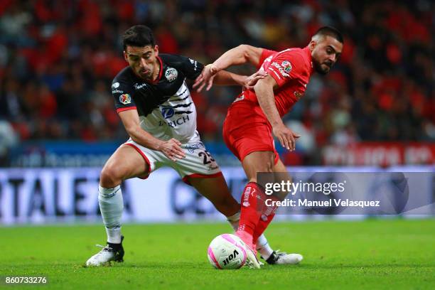 Juan Carlos Garcia of Lobos BUAP struggles for the ball with Alexis Canelo of Toluca during the 13th round match between Toluca and Lobos BUAP as...