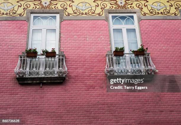 windows on colorful  wall - braga district stock-fotos und bilder