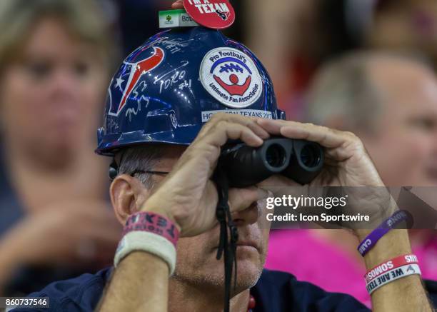 Houston Texans fan uses binoculars to look at the field during the football game between the Kansas City Chiefs and Houston Texans on October 8, 2017...