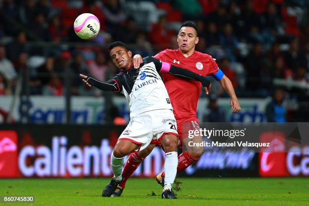 Juan Carlos Medina of Lobos BUAP struggles for the ball with Antonio Rios of Toluca during the 13th round match between Toluca and Lobos BUAP as part...