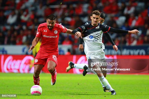 Alexis Canelo of Toluca struggles for the ball with Rodrigo Godinez of Lobos BUAP during the 13th round match between Toluca and Lobos BUAP as part...