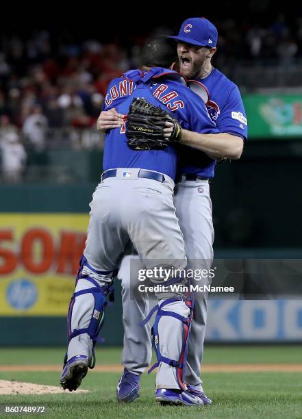 Willson Contreras of the Chicago Cubs hugs teammate Wade Davis after the final out of Game 5 of the National League Divisional Series at Nationals...