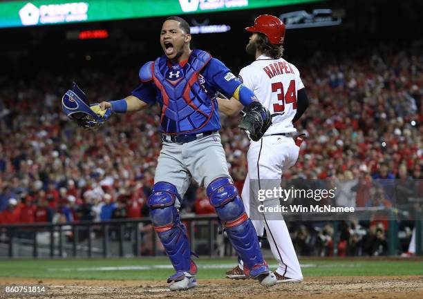 Willson Contreras of the Chicago Cubs celebrates next to Bryce Harper of the Washington Nationals after Harper struck out to end Game 5 of the...