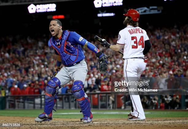 Willson Contreras of the Chicago Cubs celebrates next to Bryce Harper of the Washington Nationals after Harper struck out to end Game 5 of the...