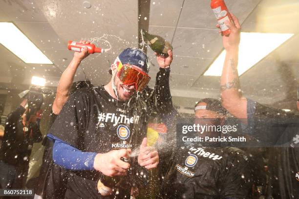 Kris Bryant of the Chicago Cubs celebrates in the clubhouse with teammates after defeating the Washington Nationals 9-8 in game five of the National...