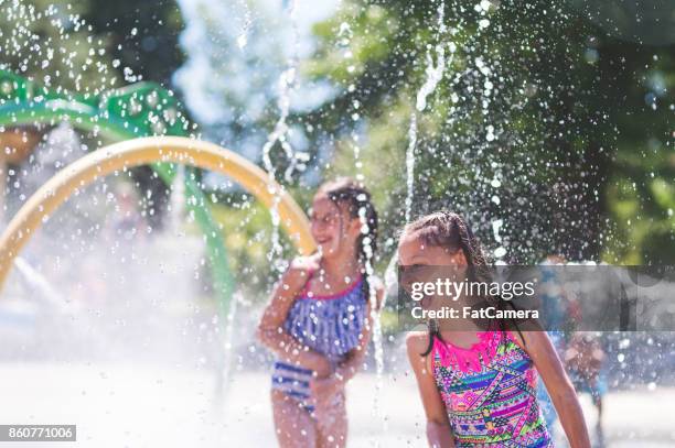 zomermiddag op de splash-pad - fontein stockfoto's en -beelden