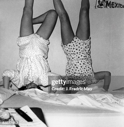 Children playing upside-down on bed Children playing upside-down on bed