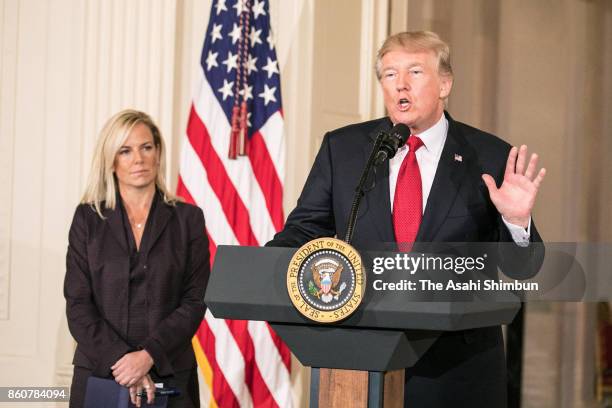 President Donald Trump speaks as White House Deputy Chief of Staff Kirstjen Nielsen looks on during a nomination announcement at the East Room of the...