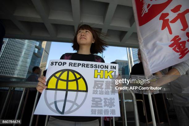 Pro-democracy activist holds a placard during a protest outside the High Court in Hong Kong October 13 as jailed activist Joshua Wong marks his 21st...