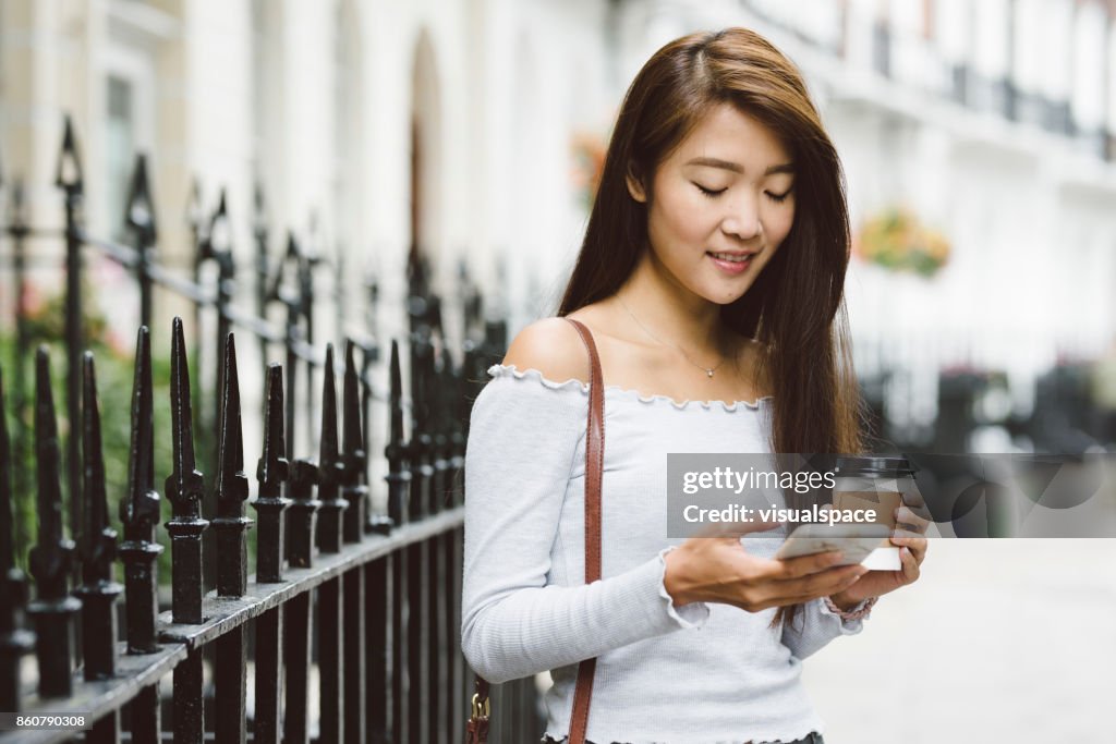 Giovane studente asiatico che usa il telefono