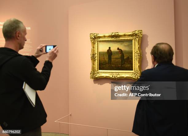 Visitors watch and take photos on October 12, 2017 of the painting "The Angelus" by French 19th Century painter of the Realism art movement,...