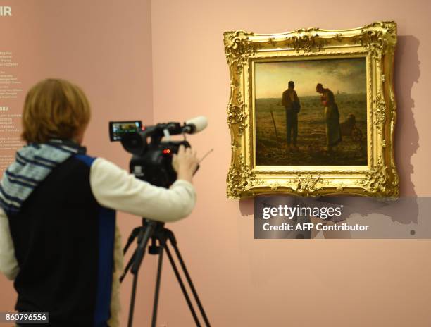 Tv journalist works on October 12, 2017 bythe painting "The Angelus" by French 19th Century painter of the Realism art movement, Jean-François...