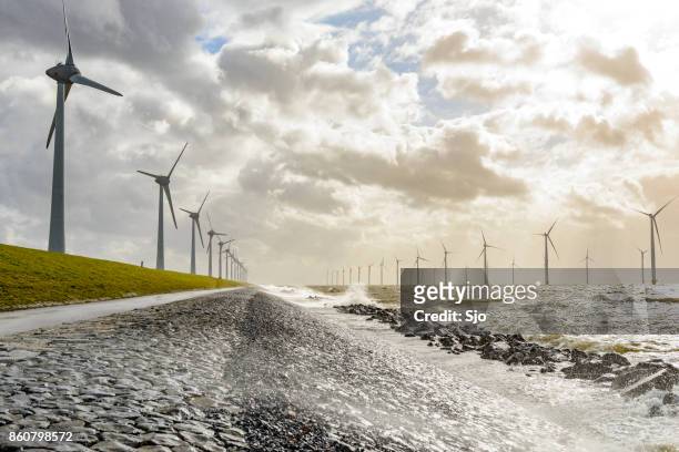 windturbines op land en offshore in een storm - netherlands stockfoto's en -beelden