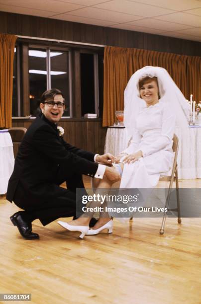 groom taking garter off bride - kneeling stock pictures, royalty-free photos & images