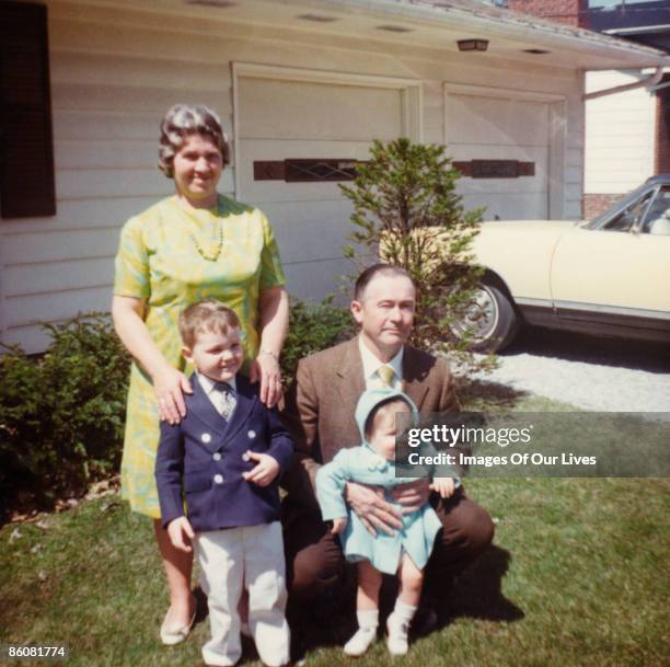 portrait of grandparents with grandchildren posing in yard - ages 65 70 stockfoto's en -beelden