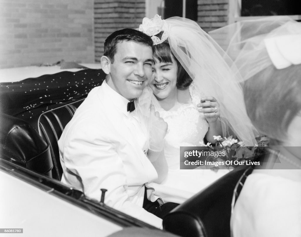 Newlyweds smiling in convertible