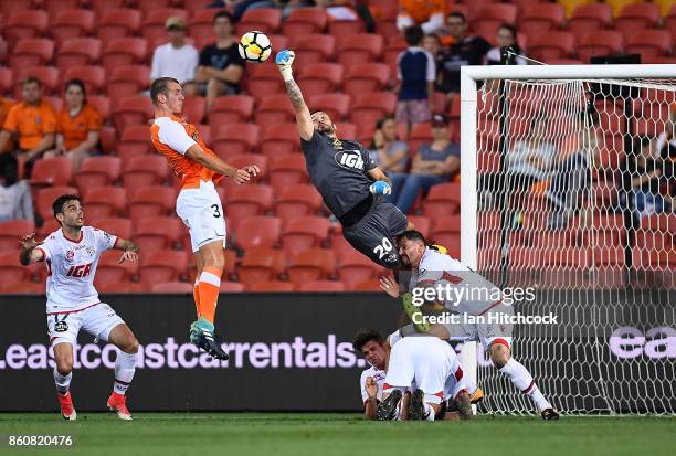 Paul Izzo of Adelaide United punches the ball away ahead of Luke De Vere of the Roar during the round two A-League match between the Brisbane Roar...