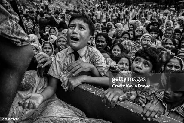 Rohingya refugee boy desperate for aid cries as he climbs on a truck distributing aid for a local NGO near the Balukali refugee camp on September 20,...