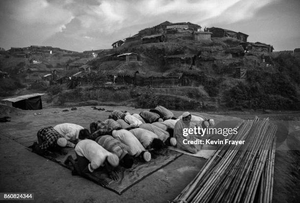 Rohingya refugees pray at the site where they are building a new mosque at the sprawling Balukali refugee camp on September 25, 2017 in Cox's Bazar,...