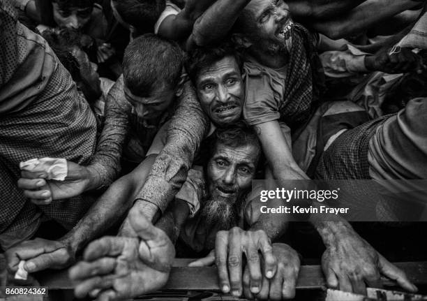 Rohingya refugees desperate for aid crowd as food is distributed by a local NGO near the Balukali refugee camp on September 20, 2017 in Cox's Bazar,...