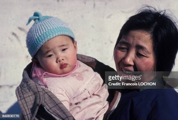 Une femme tient un enfant dans ses bras en janvier 1978 en Chine.