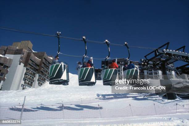 Téléphérique et skieurs en février 1984 aux Menuires, France.