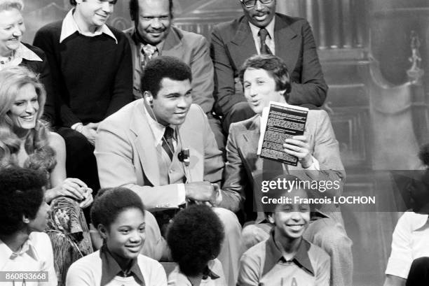 Le boxeur Mohammed Ali à la télévision pour présenter son autobiographie avec Michel Drucker et, Dalida, à gauche, en mars 1976 à Paris, France.