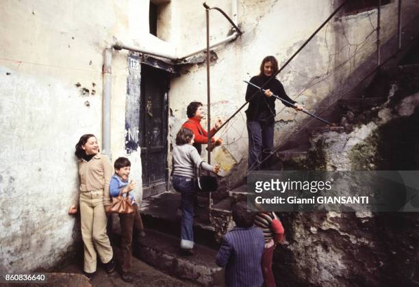 Enfants jouant sur un escalier dans une rue, circa 1980 à Naples, Italie.