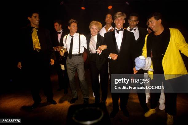 La chanteuse Nicole Croisille entourée de la troupe des Chippendales lors d'un spectacle dans un cabaret, circa 1990, à Paris, France.