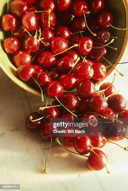 cherries spilling from bowl - bing cherry stock pictures, royalty-free photos & images